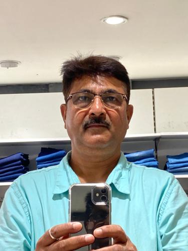 a man holding a cell phone in his hand at JIYA Guest HOUSE in Shāhpur