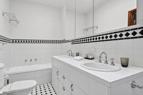 a white bathroom with a sink and a toilet at Casa del Mar in Marengo