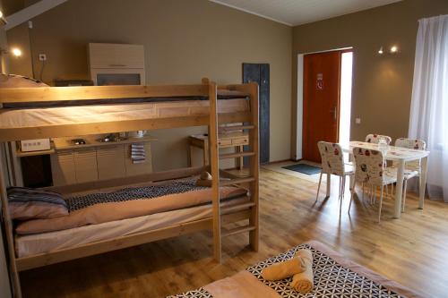 a room with bunk beds and a dining room with a table at Marbella in Ventspils