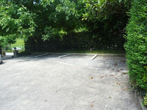 a parking lot with a hedge and trees at Casa Rural Arratzain in Usúrbil