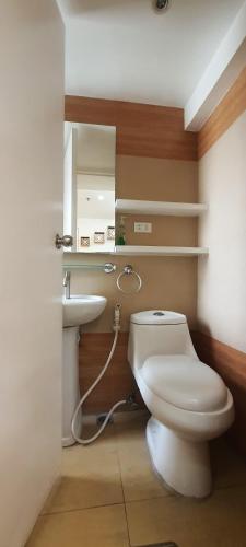 a bathroom with a white toilet and a sink at 2 BR loft-type condo Fort Victoria in Manila