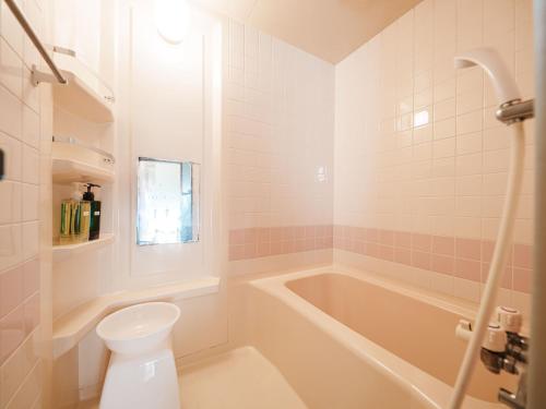 a bathroom with a tub and a toilet and a sink at Irori Cabin biei in Biei