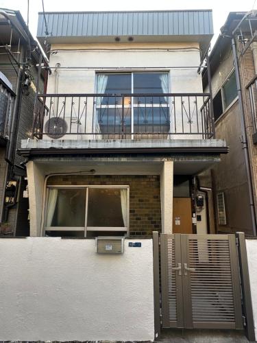 a house with a balcony and a gate in front of it at Omori Tei大森亭OMT 18min to Haneda, 3min Omori, Max 7 people in Tokyo