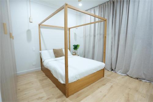 a bedroom with a canopy bed with white sheets at The Oak & Sand House 3BHK Cosy stay in Modbury