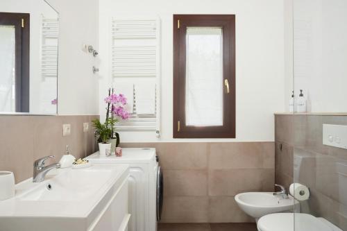 a bathroom with two sinks and a toilet at Tropical Fruit Garden Villa In Lido Di Noto in Noto