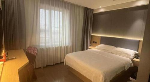a hotel room with a bed and a desk at Green Tree Inn Urumqi San'gong Metro Station Exit in Ürümqi