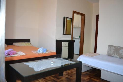 een kamer met 2 bedden, een tafel en een spiegel bij Apartments Elizabet in Star Dojran