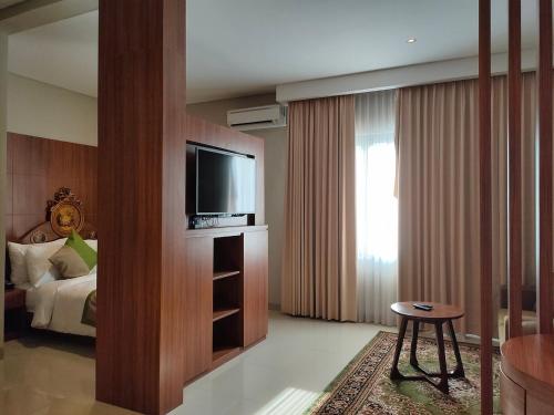 a hotel room with a television and a bed at Wyndham Garden Yogyakarta Hotel Conference & Action Park in Sleman