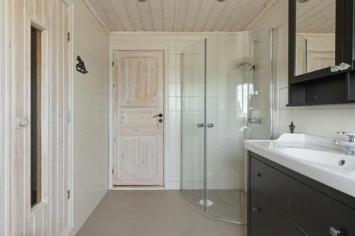 a bathroom with a shower and a sink and a mirror at Modern Family Cabin Near Vinterland Ski Resort in Lifjell