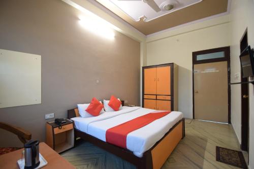 a hotel room with a large bed with red pillows at Hotel O Sky Inn in Jaipur