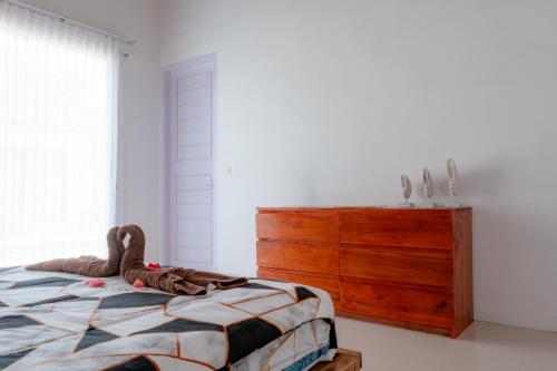 a bedroom with a bed and a wooden dresser at Tropical Villa with Swimming Pool in Selong Belanak