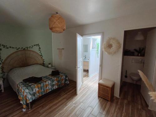 une chambre avec un lit et un couloir avec une salle de bains dans l'établissement La Casaflo, à Florensac