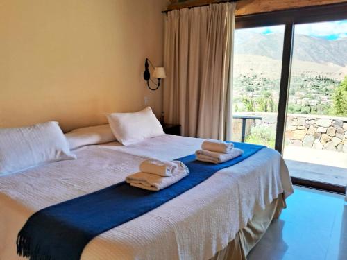 a bedroom with a bed with towels on it at canto del viento in Tilcara