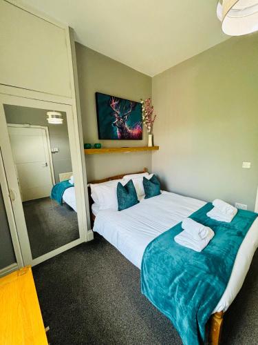 a bedroom with a large bed with towels on it at Garrick's Suite-Home away from Home- suitable for couples retreat, Contractors and NHS- free parking in Southport