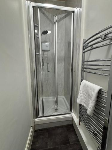 a shower with a glass door in a bathroom at Garrick's Suite-Home away from Home- suitable for couples retreat, Contractors and NHS- free parking in Southport