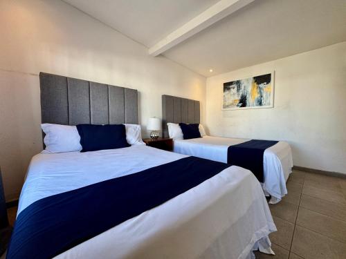 a hotel room with two beds in a room at Casa Petri Hotel in Ensenada