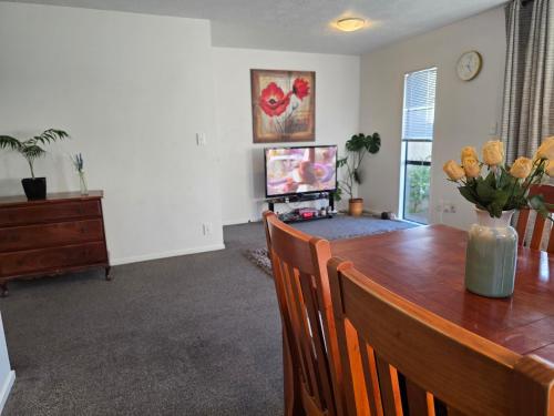 a dining room with a table and a television at 3-Bedrooms Home near CBD in Christchurch