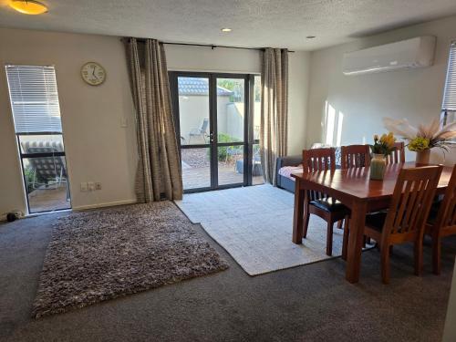 a dining room with a table and chairs and a view of a patio at 3-Bedrooms Home near CBD in Christchurch
