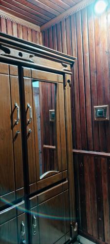 a wooden cabinet with a mirror in a room at Banasura Green paradise , Villa , Deluxe rooms , Budget rooms in Padinjarathara
