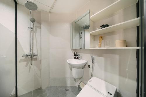 a bathroom with a toilet and a shower and a sink at Alumas Home in Hanoi