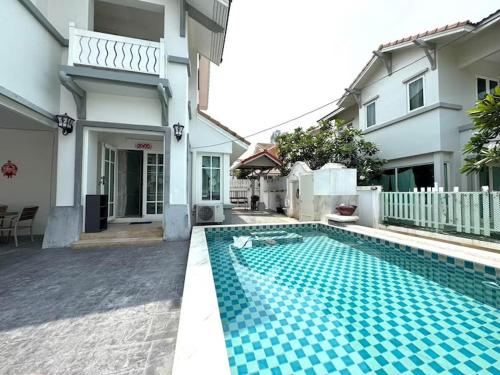 a swimming pool in front of a house at Warisa Garden Pool Villa in Jomtien Beach