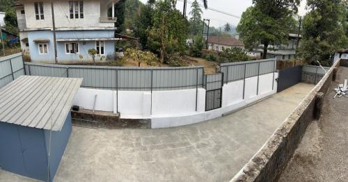 a fence on the side of a building at Fog view cottage - Homestay with food and internet in Vythiri