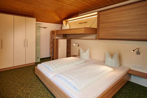 a bedroom with a bed and a bunk bed at Frühstückspension Anja in Kleinarl