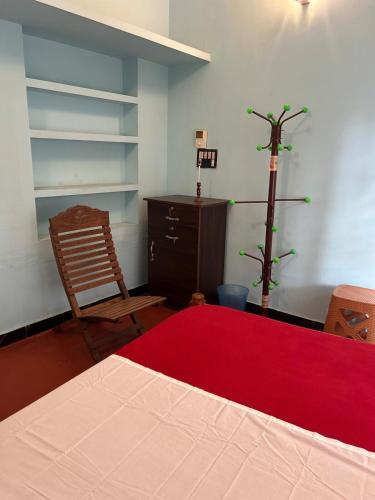 a bedroom with a bed and a dresser and a red rug at Fog view cottage - Homestay with food and internet in Vythiri