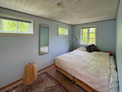 une petite chambre avec un lit et deux fenêtres dans l'établissement Holiday Home With Field Views & Fanefjord Charm, à Askeby