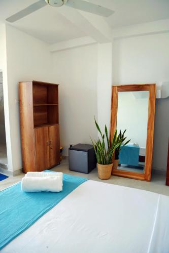 a bedroom with a bed and a mirror at Cocos in Midigama