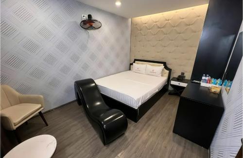 a small bedroom with a bed and a chair at Golden Hotel in Hanoi