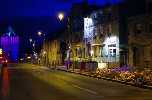 an empty city street at night with buildings and lights at Hôtel Le Roosevelt in Givet