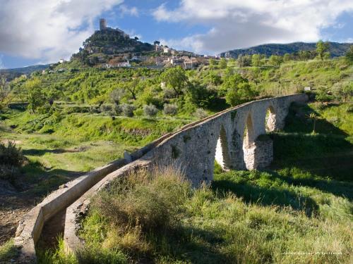 an old stone bridge with a village on a hill at Casa Rural Sant Antoni in Biar