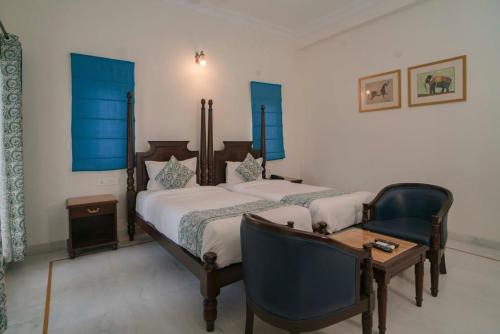 a bedroom with two beds and a desk and a chair at Villa Sagat Raaso in Udaipur