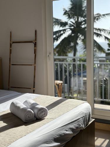a bedroom with towels on a bed with a window at Thira House in Varkala