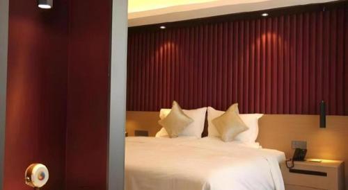 a bedroom with a white bed with a red wall at Yanji Yanbian International Hotel in Yanji
