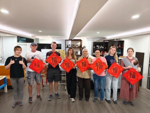 a group of people holding up kites with writing on them at Xingshe Alley Courtyard Hotel Beijing Wangfujing Forbidden City Branch - Breakfast included & English speaking reception & Free WiFi and Laundry room & Hutong Culture & Cat-keeping & Flower-growing Terrace & One day tour service & Free coffee in Beijing