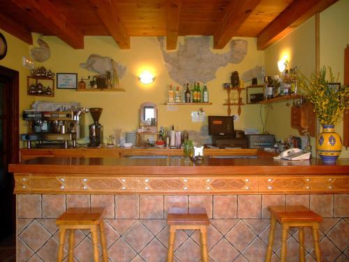 a bar in a restaurant with two stools at Hotel Rural La Puebla in Orbaneja del Castillo
