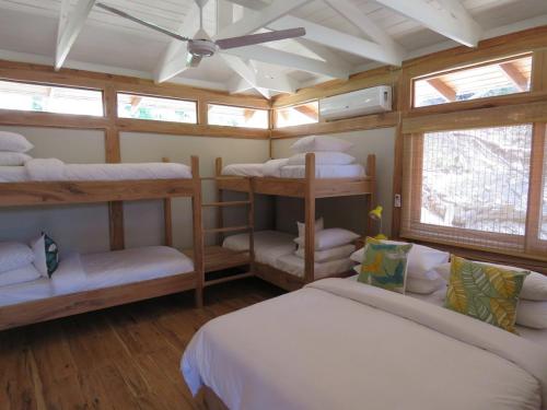 Habitación con 4 literas y ventilador de techo. en Aloha 16, en Ponta Mamoli