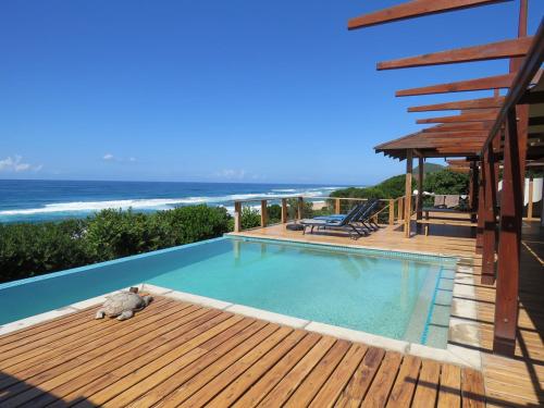 una piscina en una terraza con vistas al océano en Aloha 16, en Ponta Mamoli