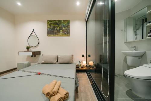 a bedroom with two beds and a glass shower at Alumas Home in Hanoi