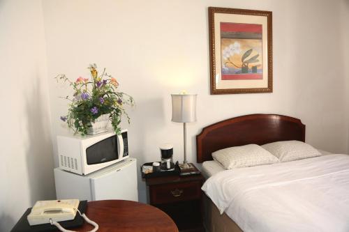 Nash Hotel في بيركلي: غرفة نوم بسرير وتلفزيون وطاولة