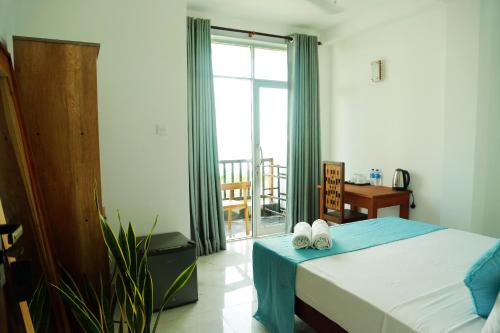a bedroom with a bed and a large window at Cocos in Midigama