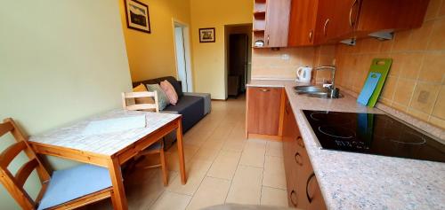 a small kitchen with a table and a couch at Józefina Apartament's blisko centrum in Szklarska Poręba