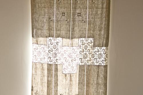 a quilt with a cross on top of a table at La Via del Carretto B&B in Capri Leone