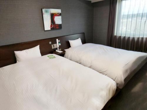 two beds in a hotel room with white sheets at Hotel Route-Inn Ena in Ena