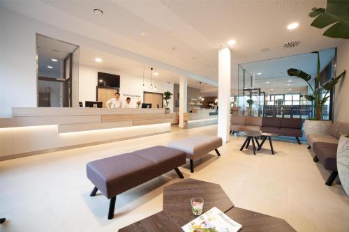 a lobby with couches and a bar in the background at Best Western Hotel Tulln in Tulln