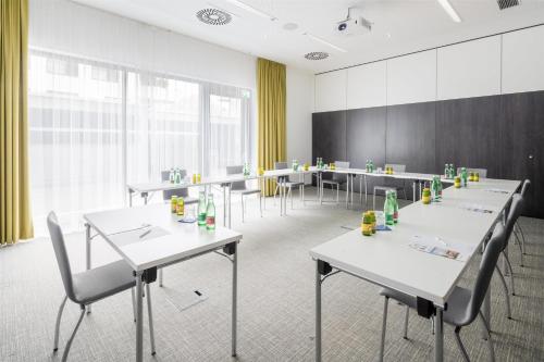 a room with tables and chairs and a large window at Best Western Hotel Tulln in Tulln