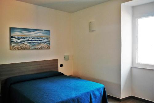 a bedroom with a bed with a blue blanket at Affittacamere Piazza Castello in Manarola