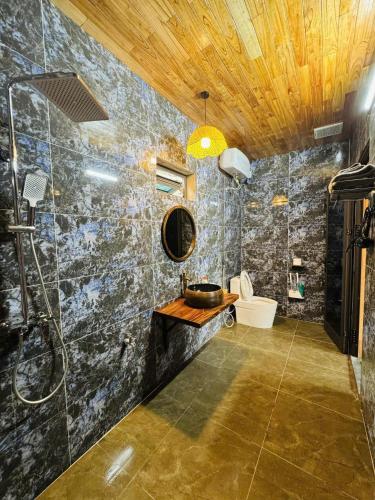 a bathroom with a shower and a sink and a toilet at Ninh Binh Mountainside Bungalow in Ninh Binh